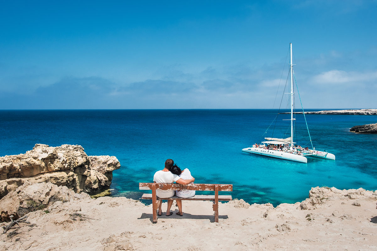 Destinations for Romance - A couple sit and admire the view in the Greek Islands